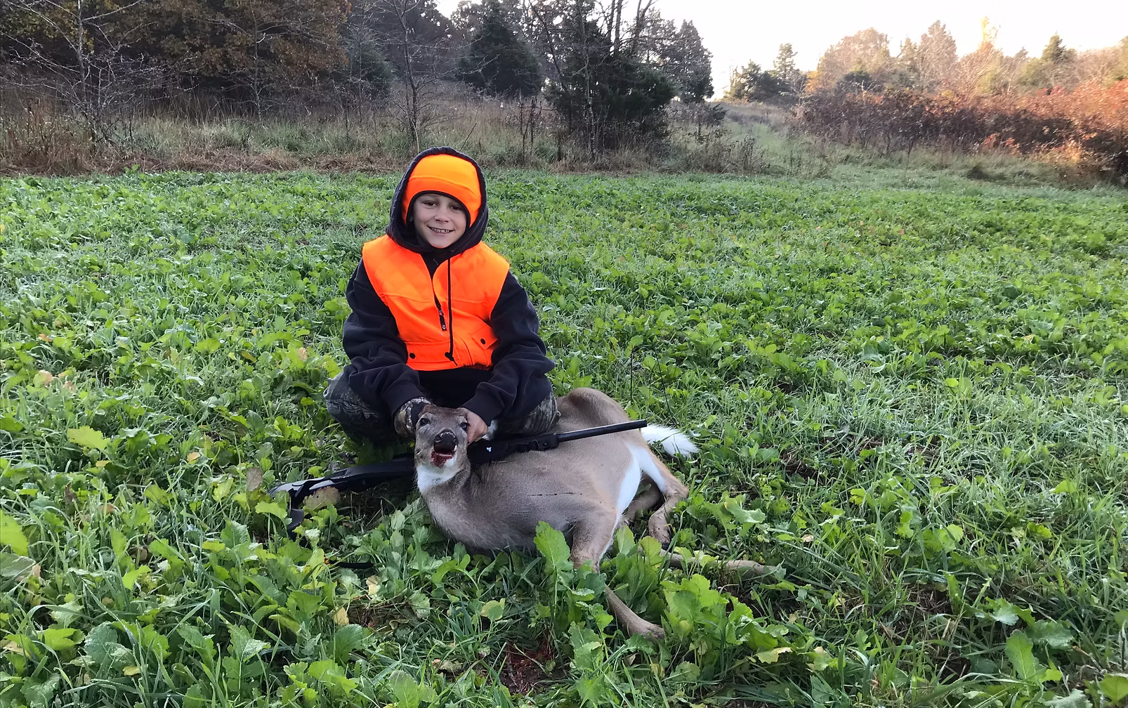 Young hunter with a whitetail deer taken over a food plot prepared by CG Dirt Work and More in northeast Oklahoma