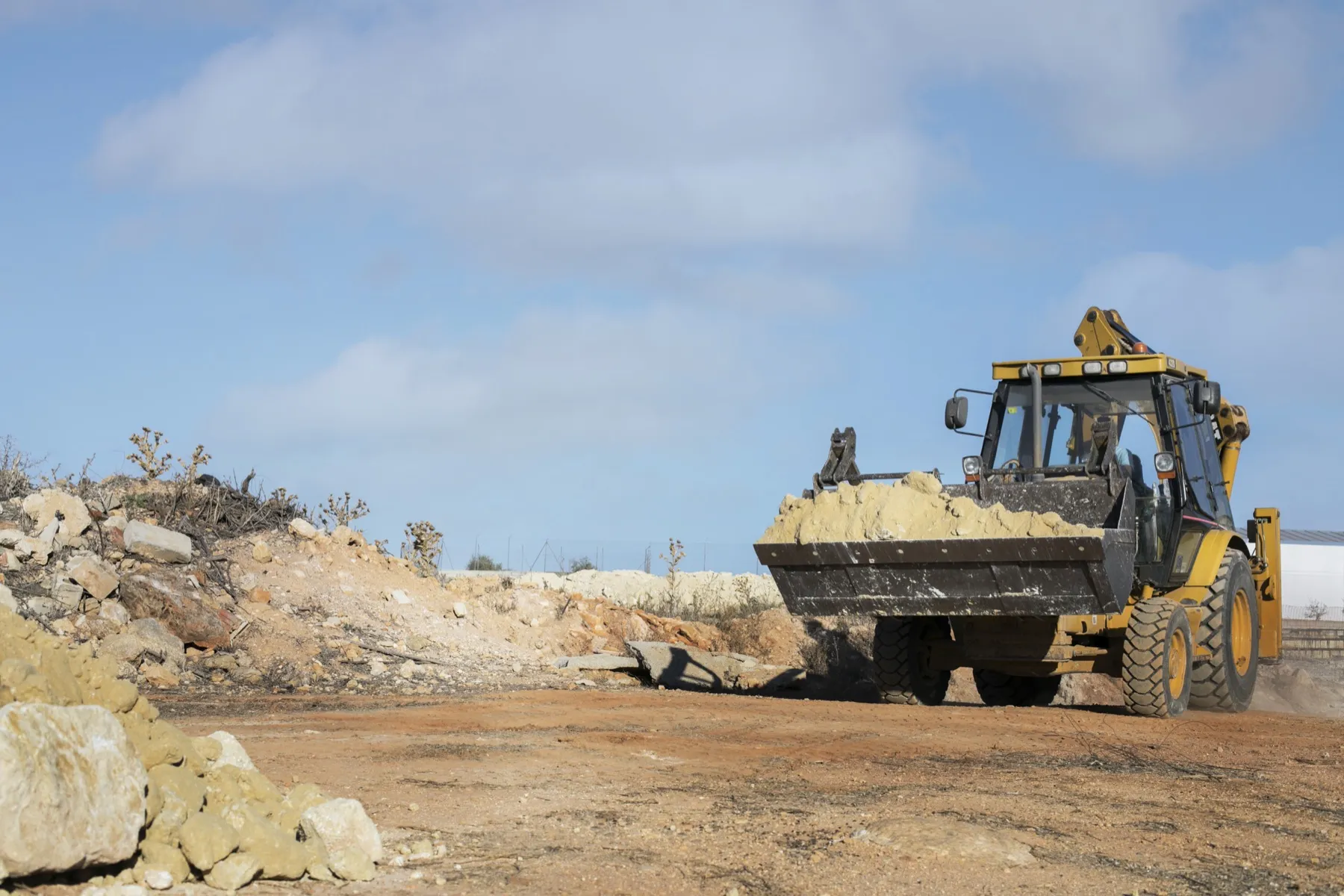 Excavator moving dirt on a cleared job site — excavation and land work by CG Dirt Work and More in northeast Oklahoma